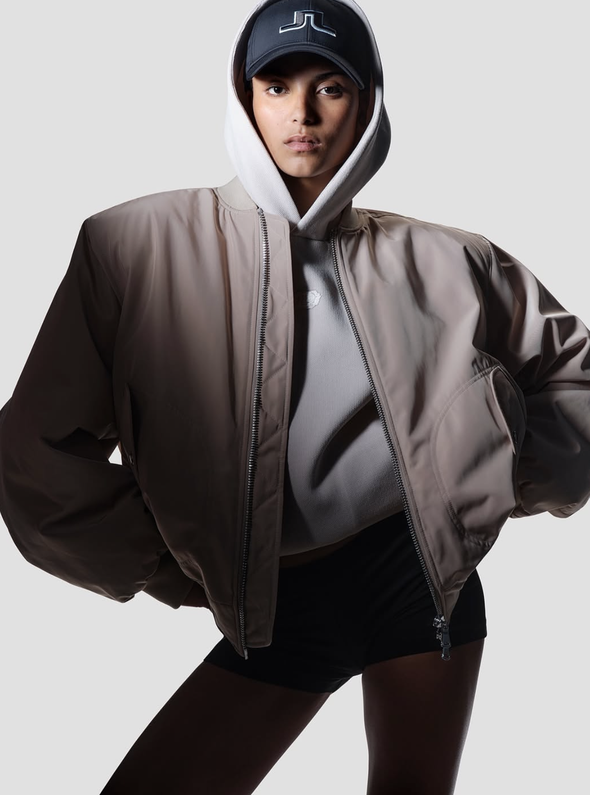 Oversized taupe technical bomber worn with hood and cap