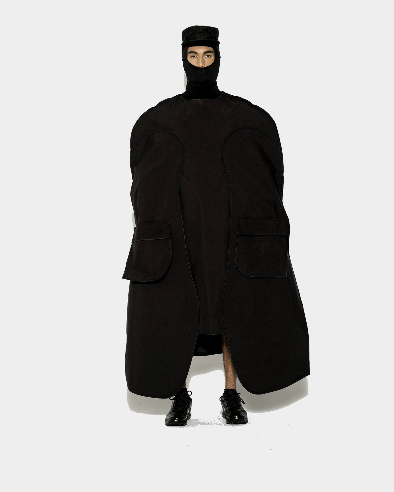 Sculptural black coat with rounded volume and balaclava